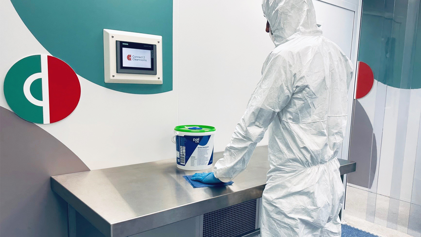 Cleanroom operator wiping stainless steel work bench