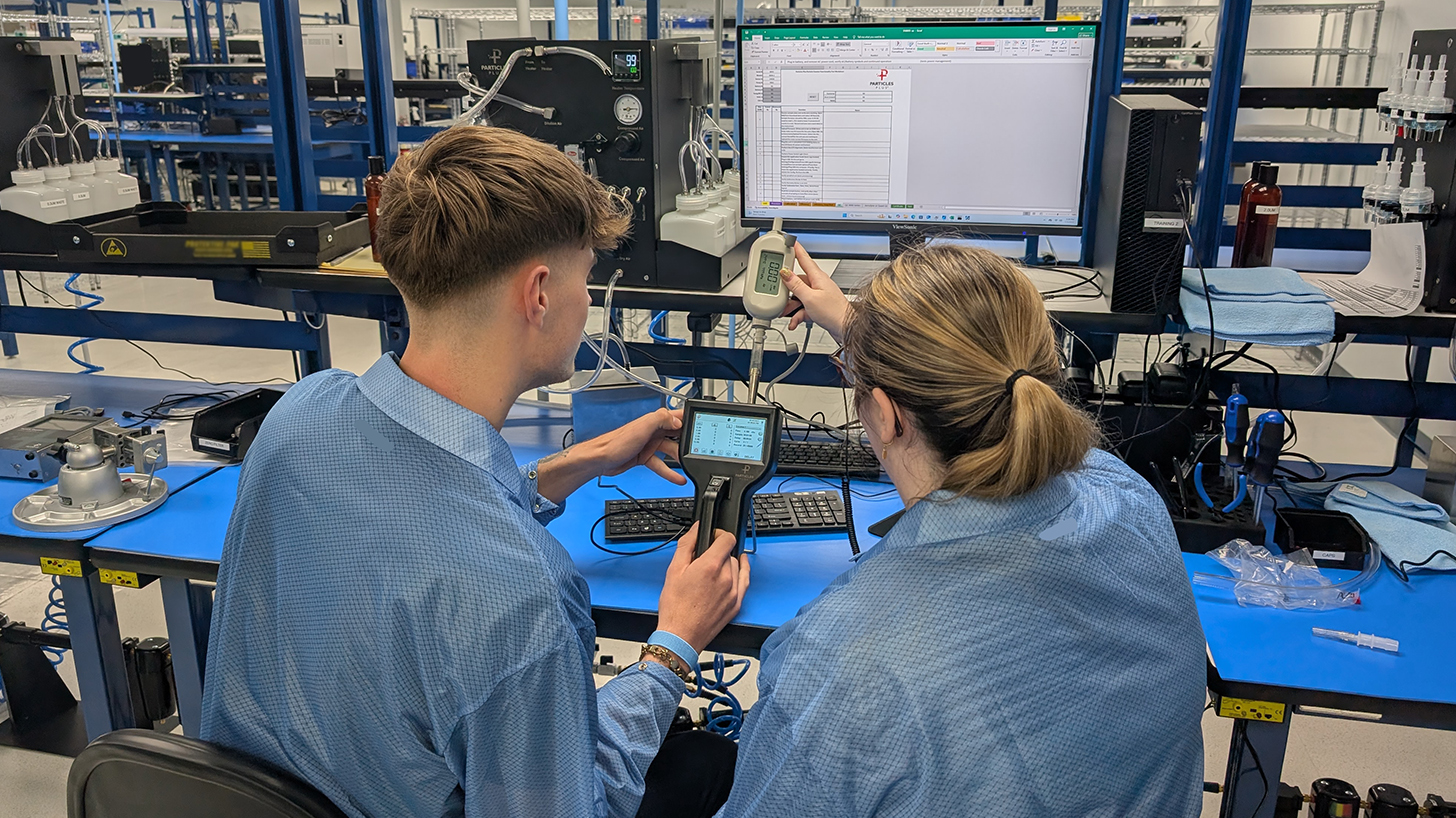 Two people calibrating a particle counter
