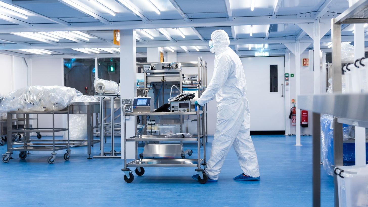 Cleanroom operator pushing a transfer trolley