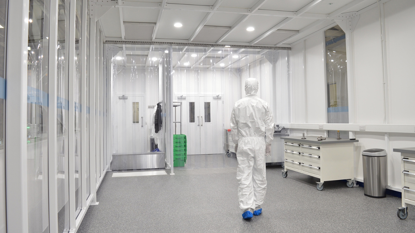 Cleanroom operator walking through a furnished cleanroom