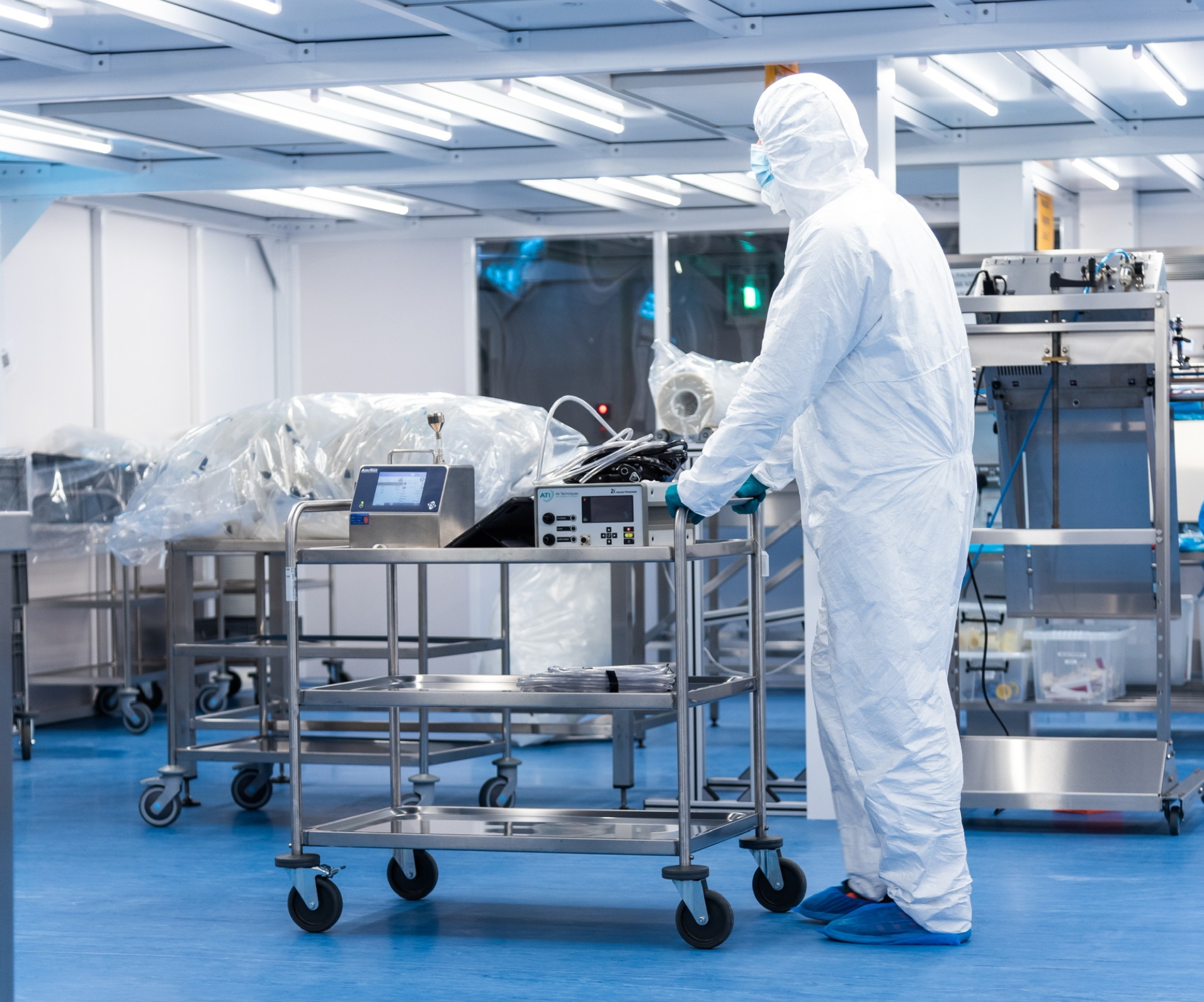Cleanroom opertor pushing a stainless steel trolley